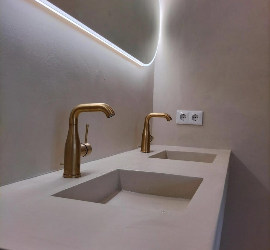 Gestucte badkamer met beton cire en gouden kranen