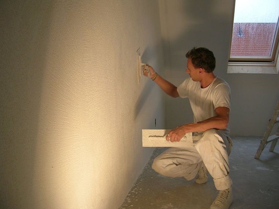 Stukadoor aan het werk aan een strakke muur in Leiden