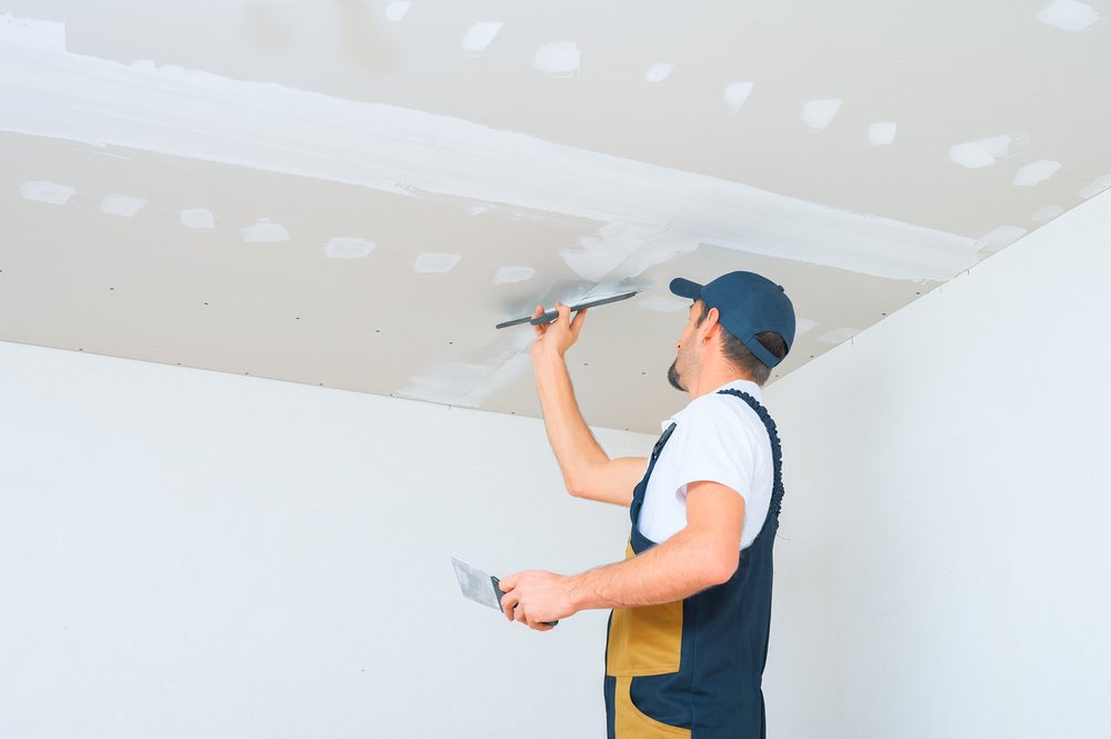 Stukadoor werkt de naden van een gipsplaten plafond af