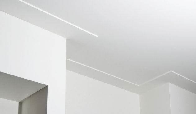 Modern gestuukt plafond met een strakke schaduwlijn als plint
